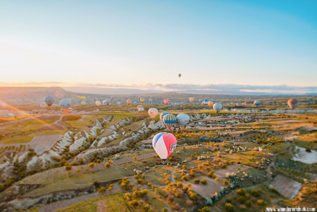 A lit view of hot air balloons flying high in Cappadocia